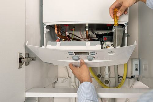 HVAC technician repairing an indoor boiler in Eloy