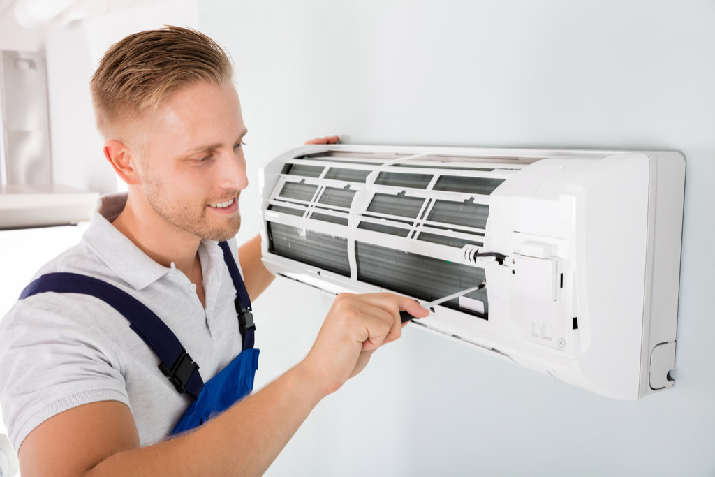 HVAC technician performing ductless air conditioning maintenance in Eloy