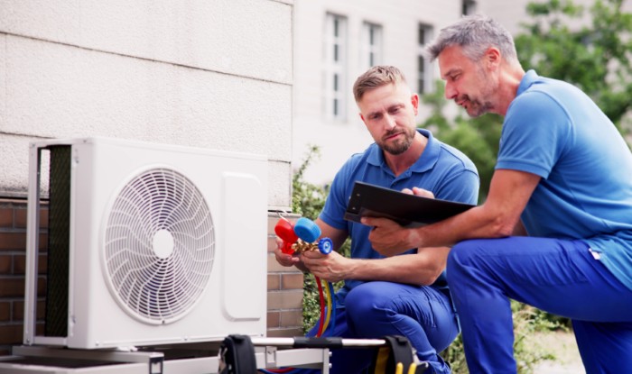 HVAC technicians installing an outdoor air conditioning unit in Eloy
