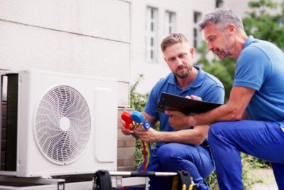 HVAC technicians reviewing an outdoor air conditioning unit in Eloy, AZ