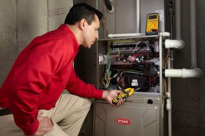 Heating and air conditioning technician servicing an indoor furnace in Eloy, AZ